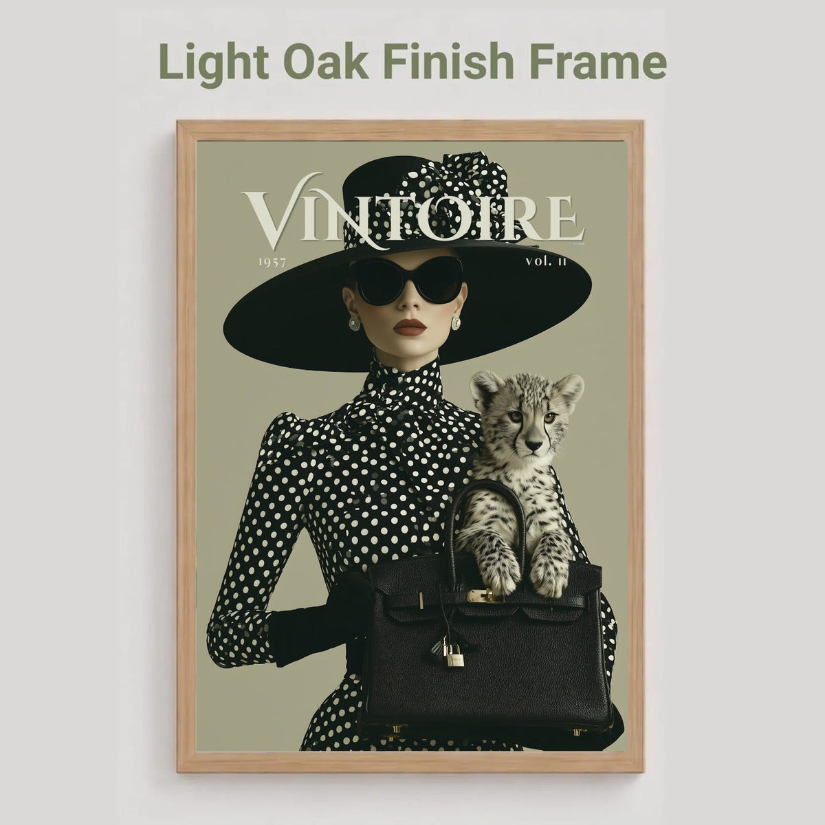 A framed art print featuring a vintage fashion illustration with the title 'VINTOIRE' and a cat, shown against a light gray background with the text 'Light Oak Finish Frame' above it.