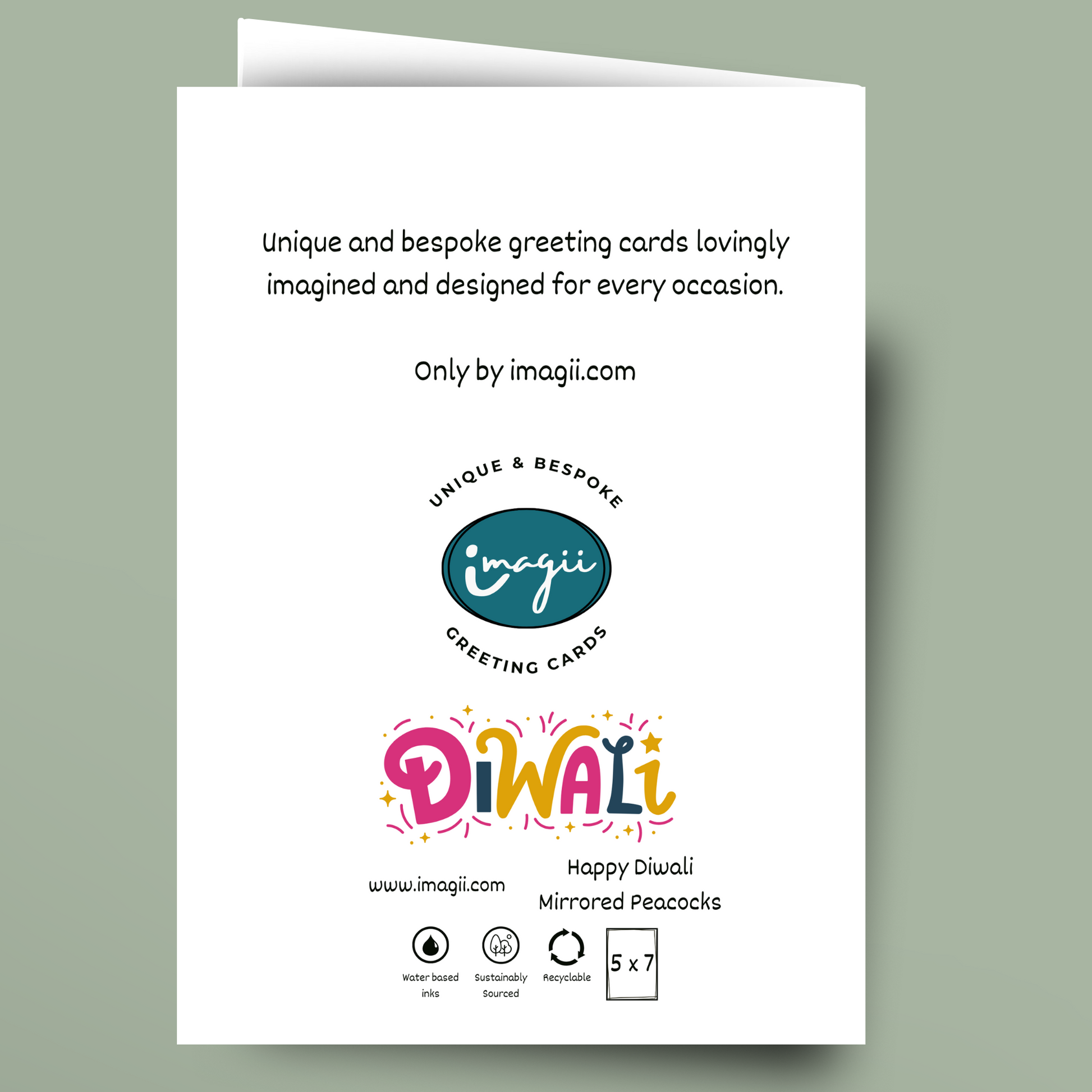 A white greeting card shown against a muted sage green background. The card features black text and colorful 'Diwali' lettering with peacock motifs, along with the Imagii brand logo and website.