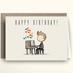 Birthday card with a cartoon illustration of a person playing music on a keyboard, with 'Happy Birthday!' text above.