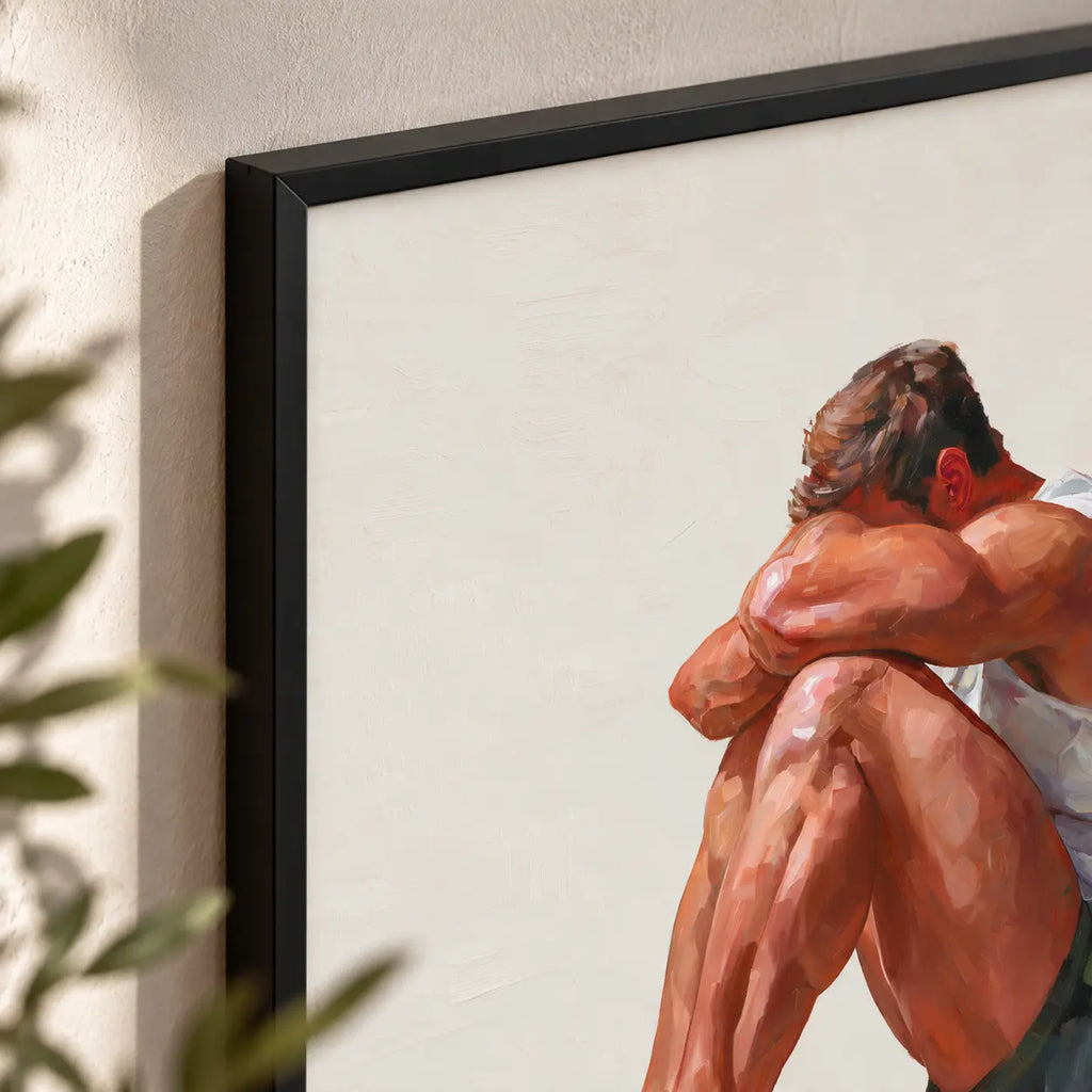 Close-up of the Rest gay art print in a black frame, showing warm blocky brushstrokes on the folded arms and knees against the off-white background