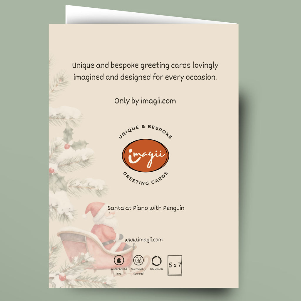A single greeting card shown flat against a muted sage green background. The card has a cream front with printed holiday illustrations along the left side, including pine branches, holly, and a pink sleigh.