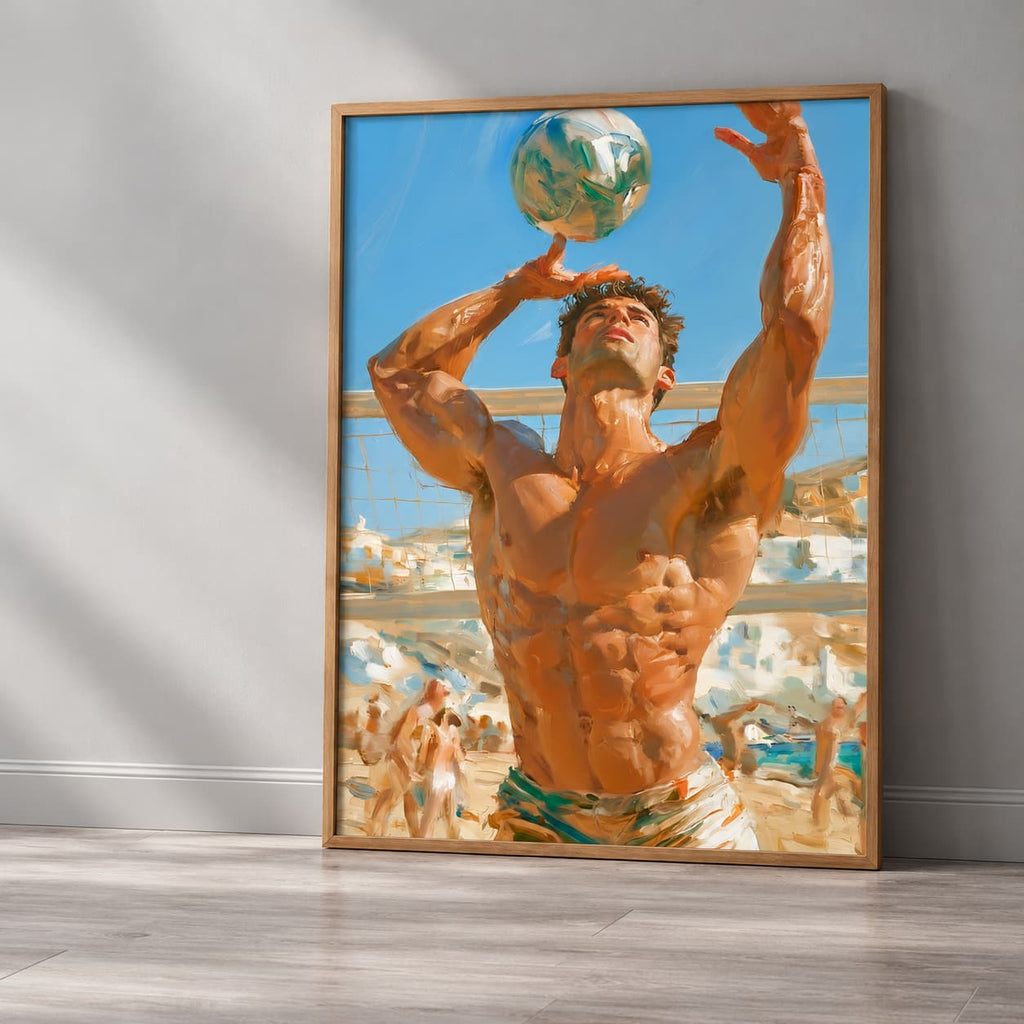 A framed vertical art print leaning against a gray wall on a light wood floor. The print shows a muscular man balancing a soccer ball on his hands in a beach town setting under a blue sky.