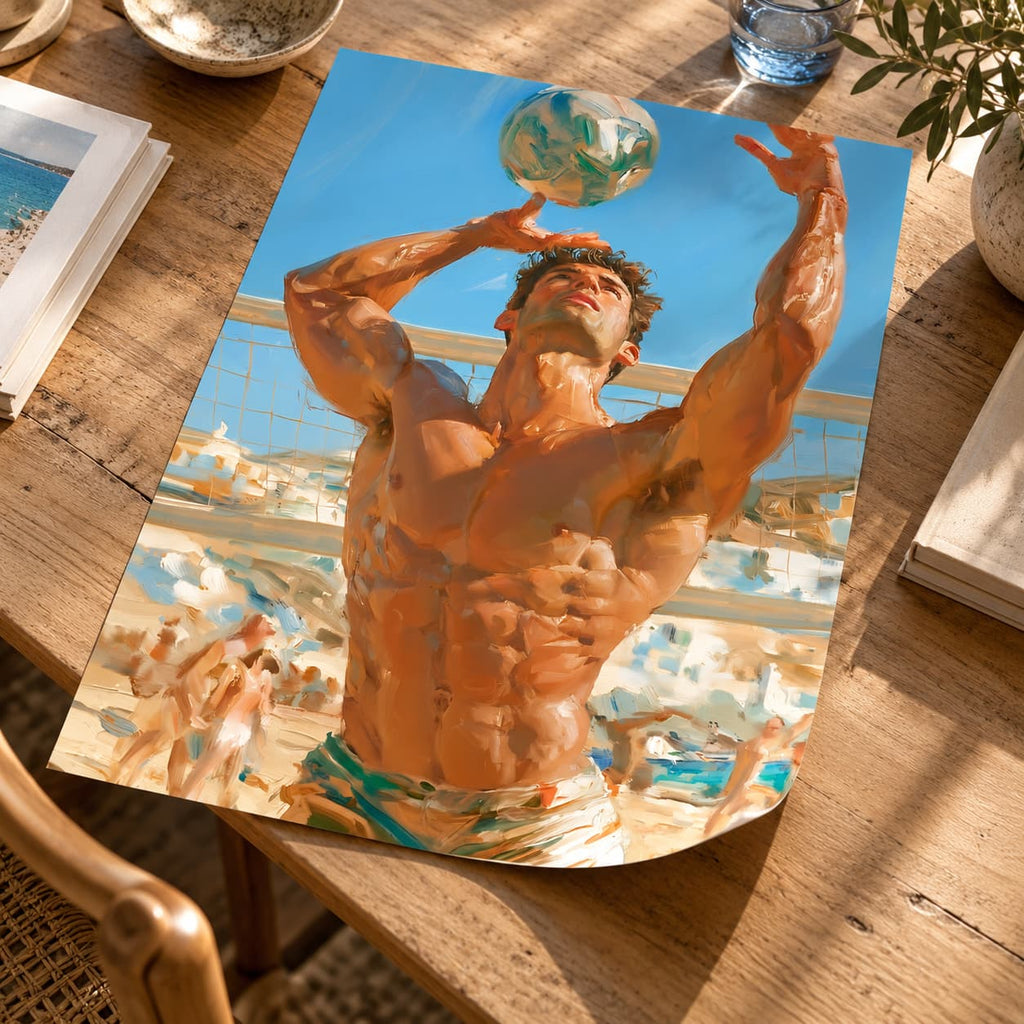 A rectangular art print or poster lying on a wooden table, showing a muscular man serving a volleyball in a beach volleyball scene under a blue sky. The print is photographed in a real environment with books, a glass, and plants around it.