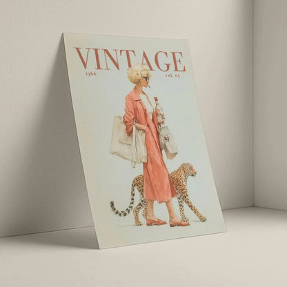 A vintage illustrated magazine titled VINTAGE, shown standing against a light neutral wall. The cover features a woman in a pink dress walking beside a cheetah, with the title 'VINTAGE' in large red letters at the top.