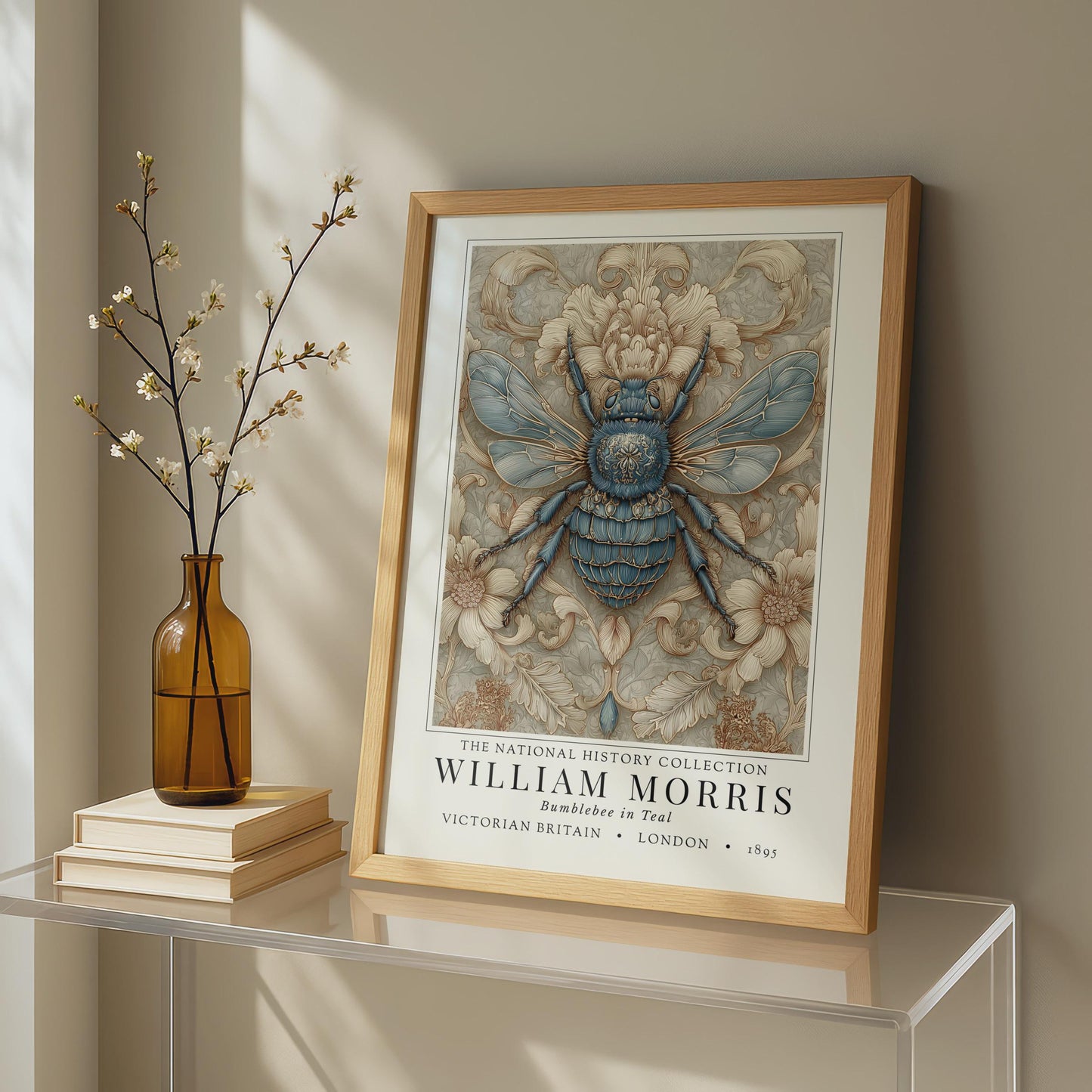 A framed William Morris art print featuring a blue and beige bumblebee, styled over a glass table