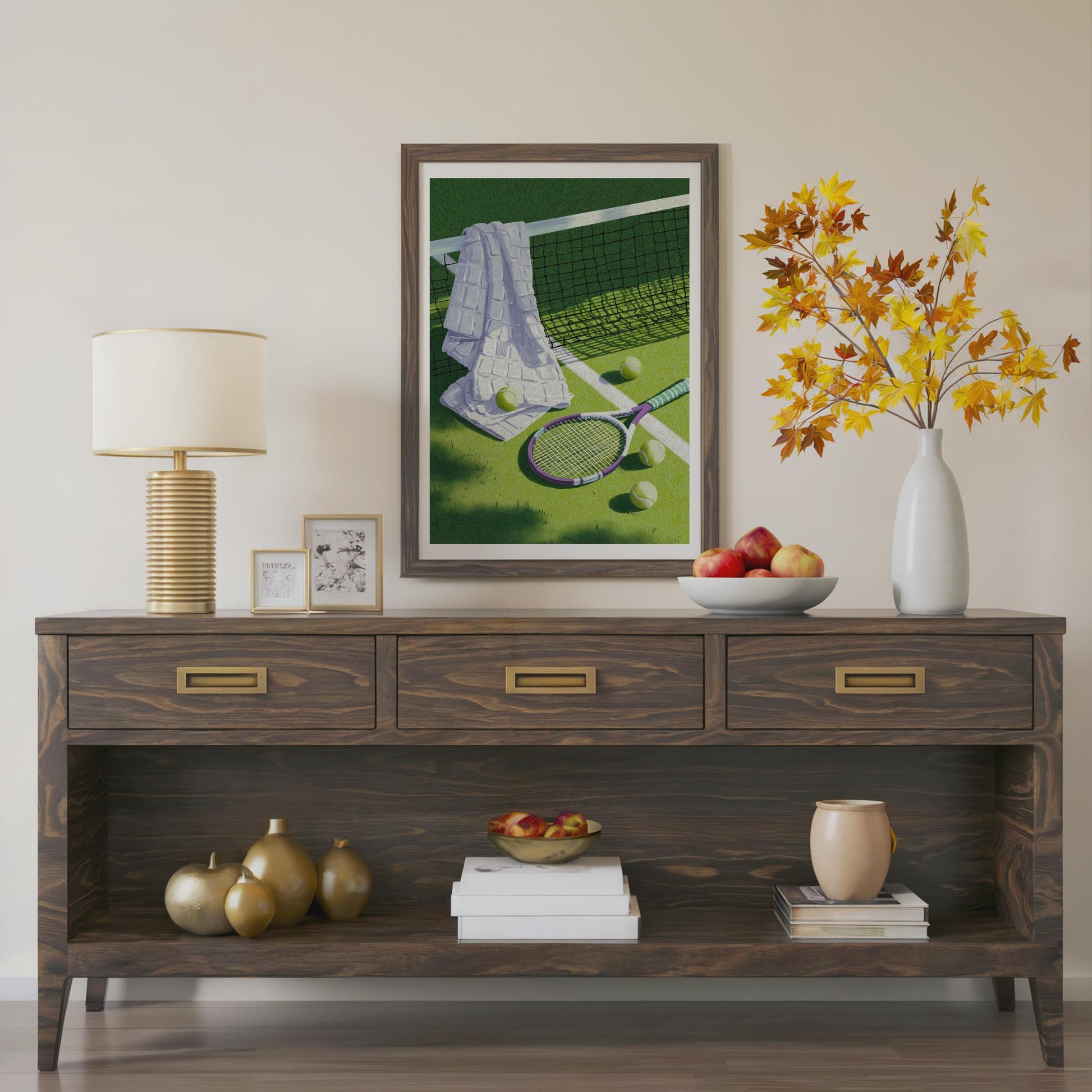 A dark brown wooden console table styled in a living room setting, featuring a framed tennis art print, a table lamp, decorative vases, books, and fruit bowls. Vintage tennis racket, towel and balls resting on a grass court, retro lilac and sage tennis wall art print