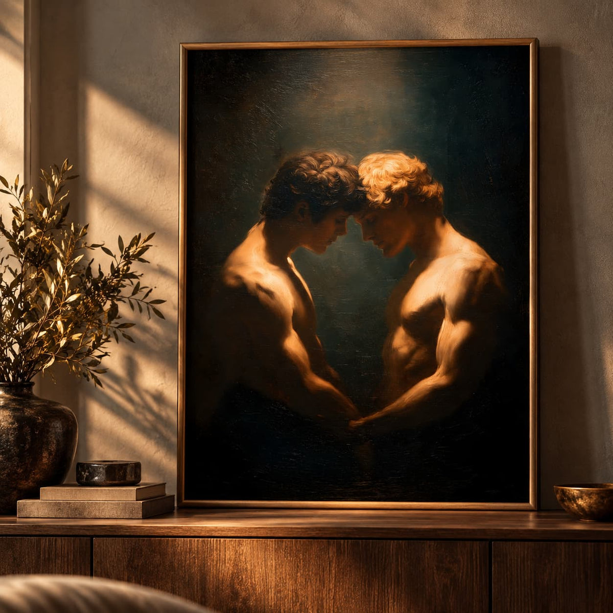 A framed classical-style painting depicting two muscular, shirtless men facing each other in dramatic warm lighting, displayed on a wooden console table in a styled interior setting.