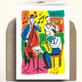 A greeting card featuring a colorful jazz musician illustration, displayed upright on top of a brown kraft envelope against a light beige background.