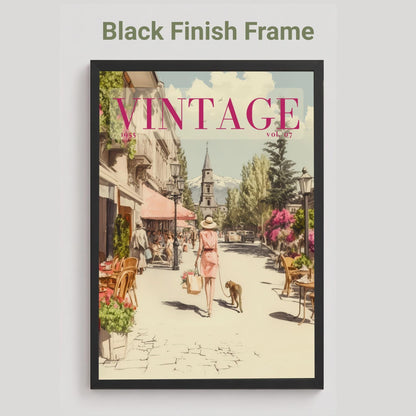 A framed art print featuring a vintage-style illustration of a European street scene with the word 'VINTAGE' in pink at the top, shown against a light gray background with the text 'Black Finish Frame' above it.