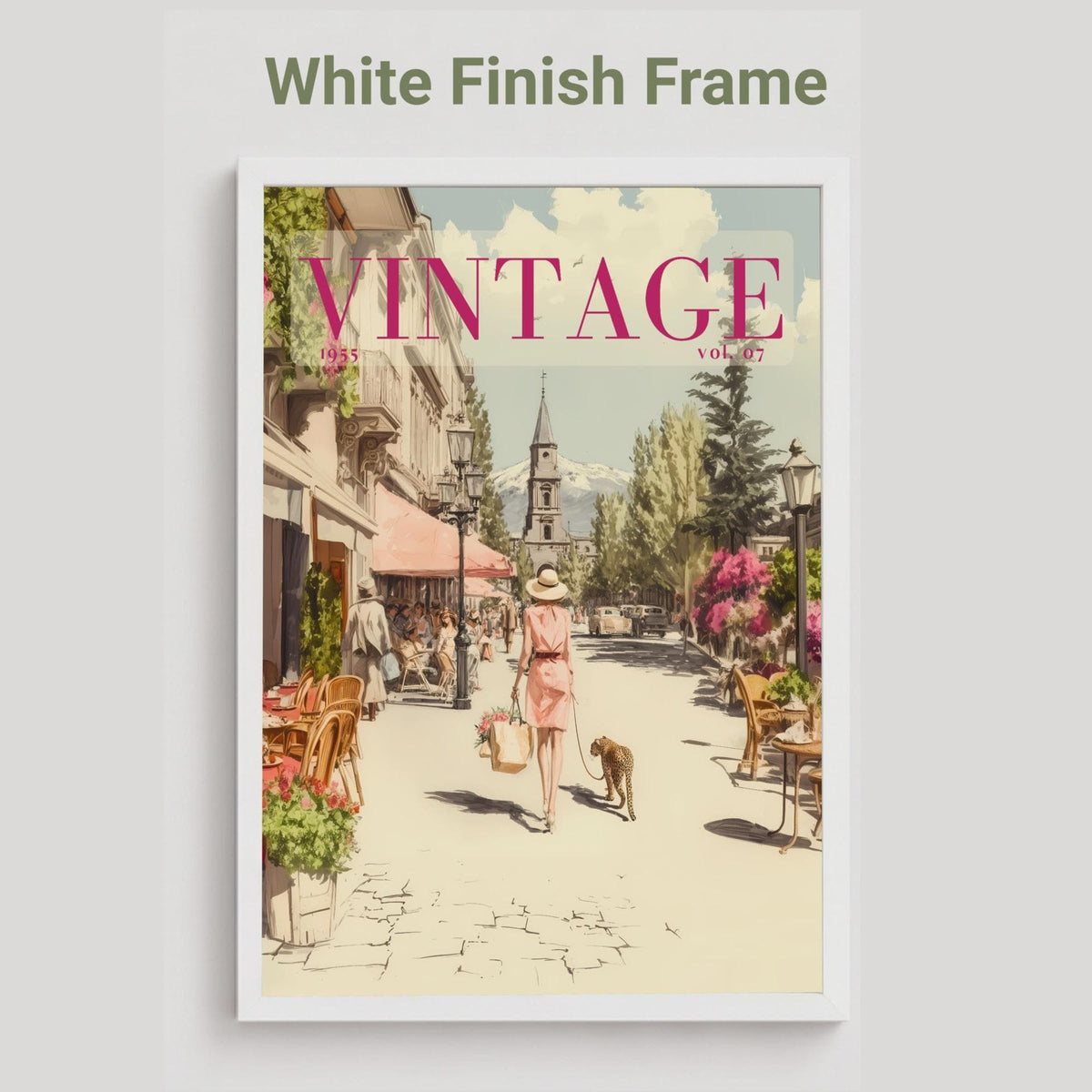 A framed art print featuring a vintage-style illustration of a European street scene with the word 'VINTAGE' in large pink letters. The print is shown with a white frame against a light gray background, with the text 'White Finish Frame' above it.