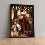 A framed vintage-style magazine cover leaning against a light gray wall on a wood floor. The cover shows the word VINTAGE at the top and a woman in a wide hat and deep burgundy dress seated beside a leopard.