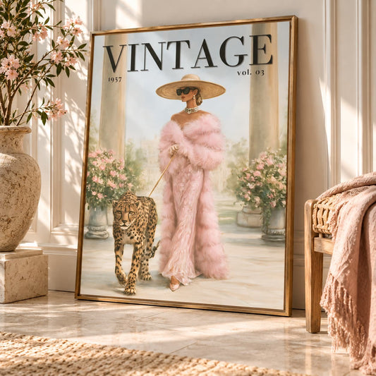 A large framed vintage-style poster leaning against a wall in a sunlit room. The poster shows a woman in a pink feathered outfit walking a leopard, with the word 'VINTAGE' and 'vol.