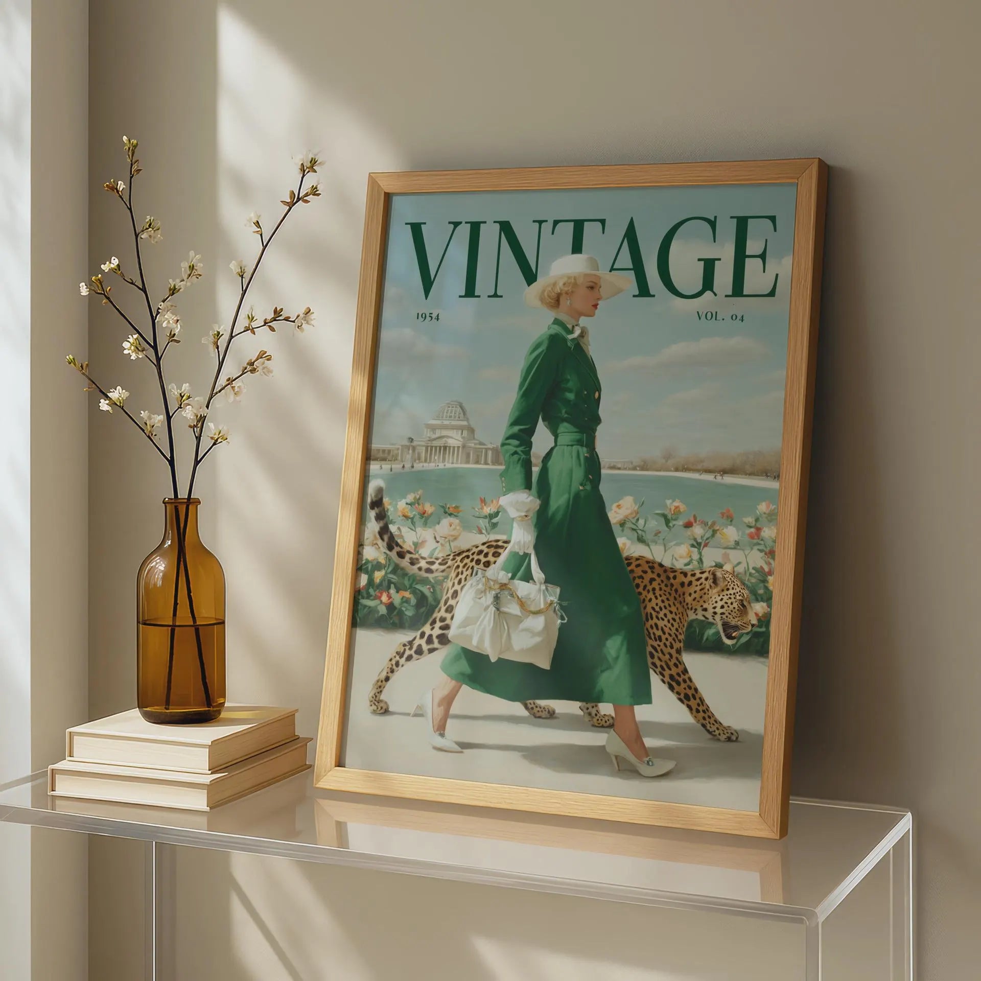 A framed vintage-style magazine cover print leaning on a glass table in a sunlit room. The cover shows the word VINTAGE prominently at the top and an illustrated woman in a green dress walking with two cheetahs.