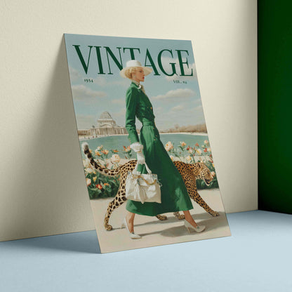 A vintage-style illustrated poster or print leaning against a wall on a light blue surface. The artwork shows a woman in a long green dress walking with two cheetahs near water and flowers, with the large word 'VINTAGE' across the top.
