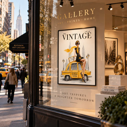 A framed vintage-style art print featuring a woman sitting on a yellow taxi cab is displayed on a city storefront window. The print reads 'VINTAGE' and includes a woman in a black dress with a yellow hat and scarf.