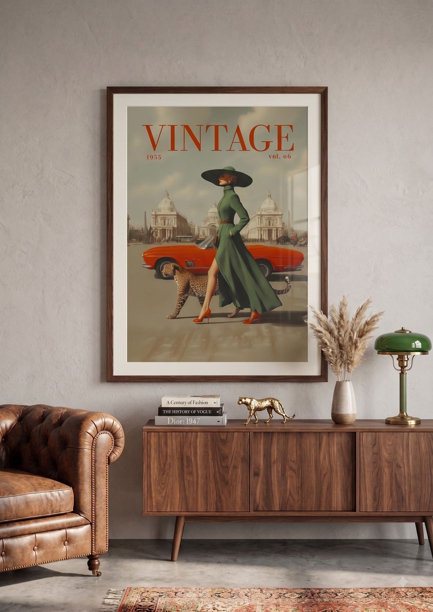 A framed vintage-style poster hangs on a light gray wall above a wooden sideboard in a styled room. The poster features the word 'VINTAGE' at the top, an orange car, a woman in a long green dress and black hat, and a dog.