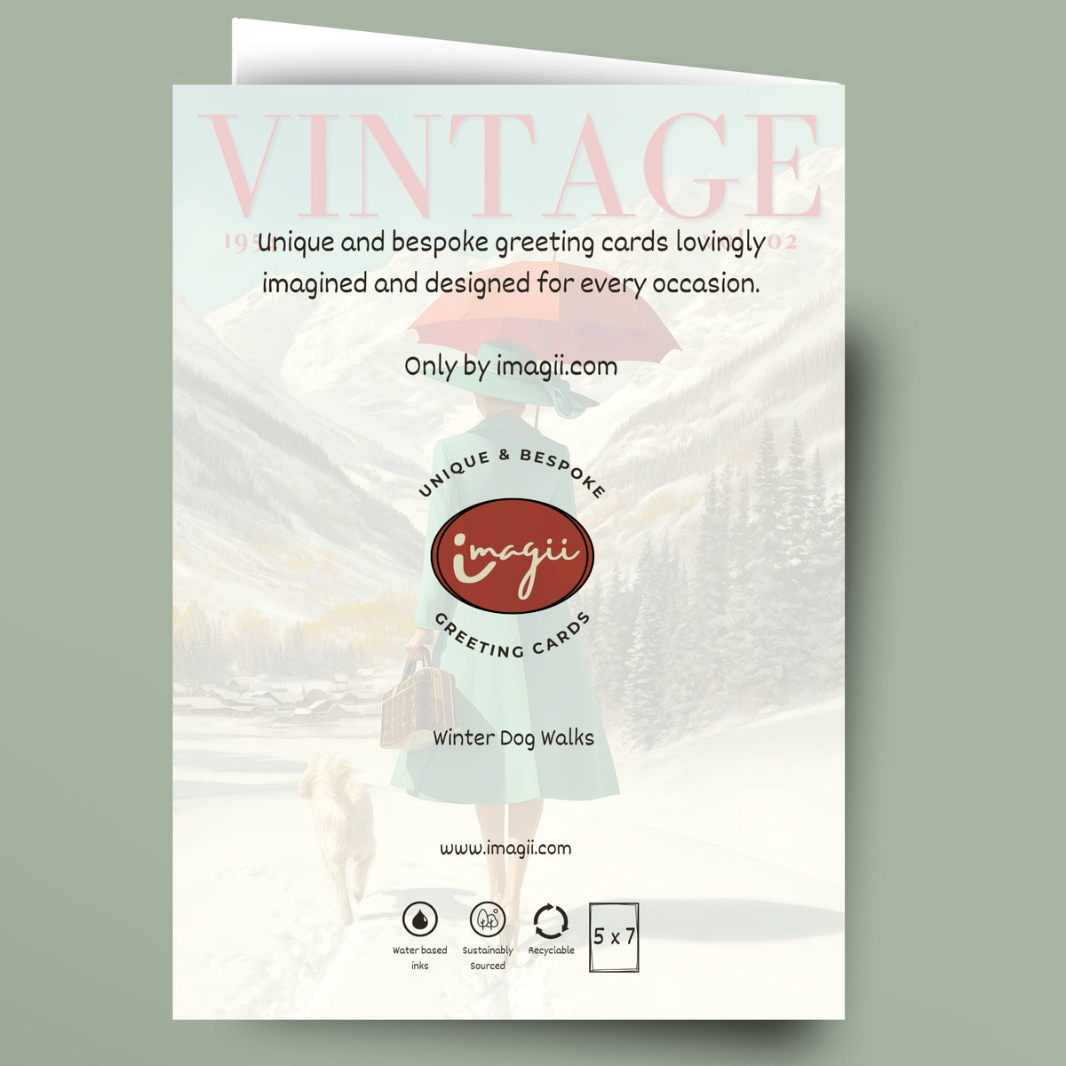 A vintage-style greeting card template shown standing against a muted sage green background. The card features a soft winter scene with a woman walking a dog in the snow, large faded pink text reading 'VINTAGE,' and central branding for 'imagii greeting cards.