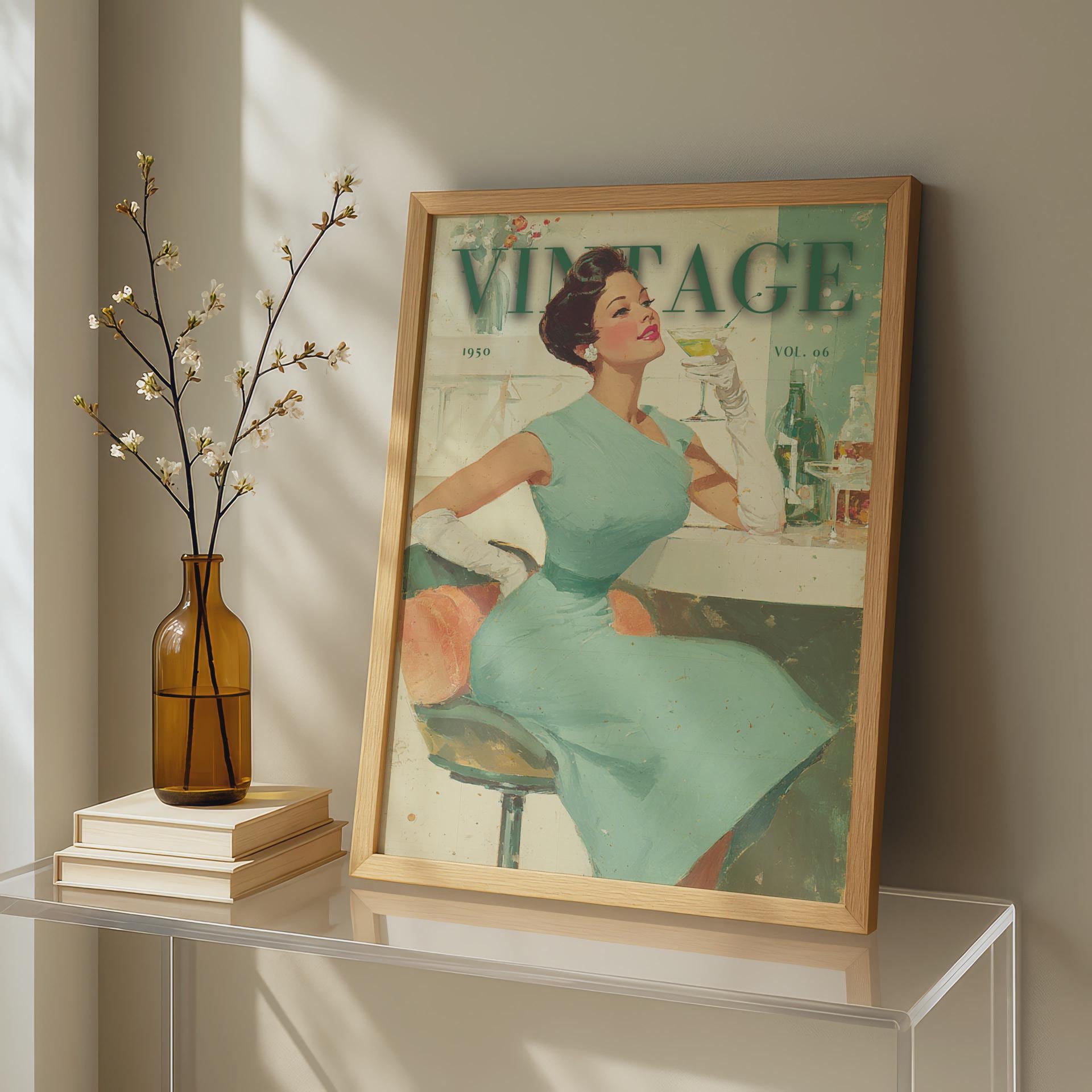 A framed vintage-style poster leaning on a glass table, showing a woman in a mint dress with the word 'VINTAGE' at the top. The room has warm sunlight, a brown glass vase with branches, and stacked books. 1950s vintage cocktail bar lady illustration in mid-century modern retro style, sage green and cream wall art print
