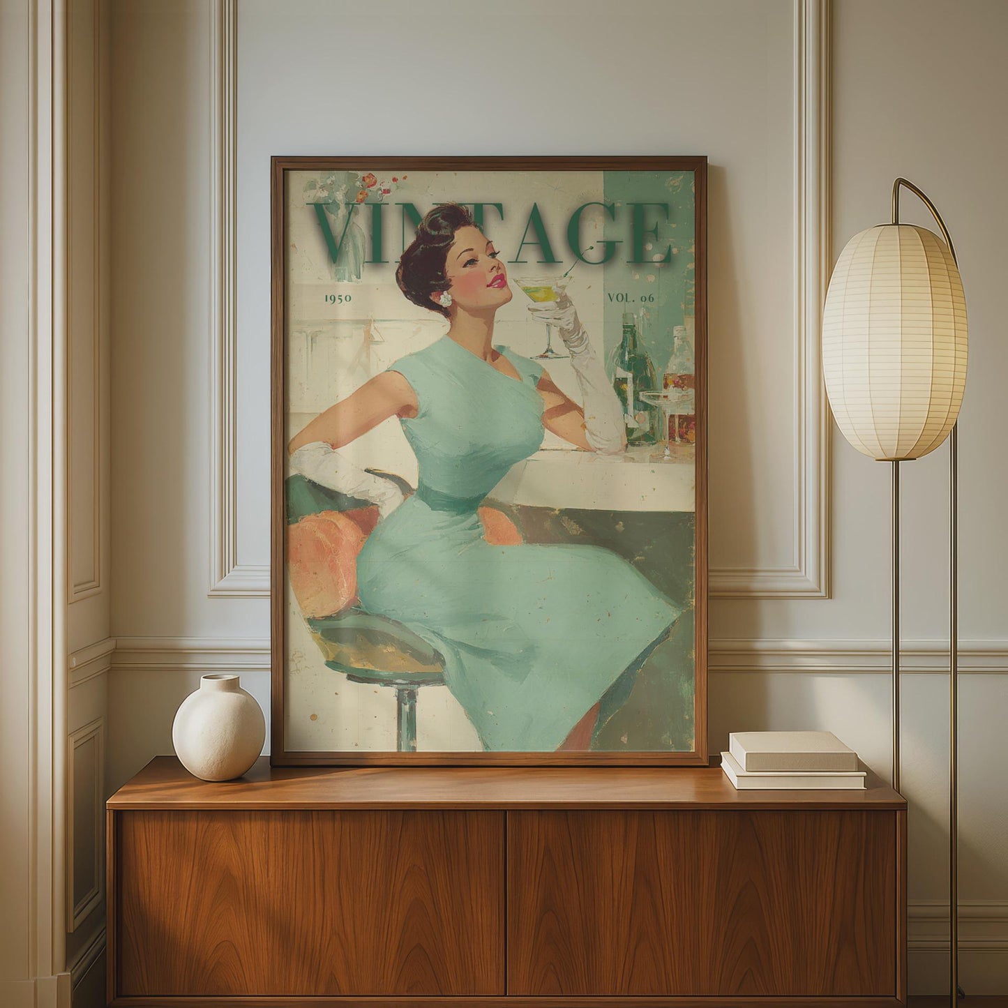 A framed vintage-style art print featuring a woman in a mint green dress on a poster, displayed on a wooden cabinet in a styled interior with a floor lamp and small vase. 1950s vintage cocktail bar lady illustration in mid-century modern retro style, sage green and cream wall art print