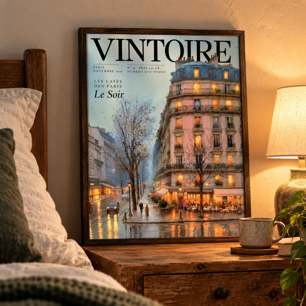 Framed Vintoire Rainy Paris magazine cover poster on a wooden bedside table beside a glowing lamp and linen pillows in a cosy bedroom.