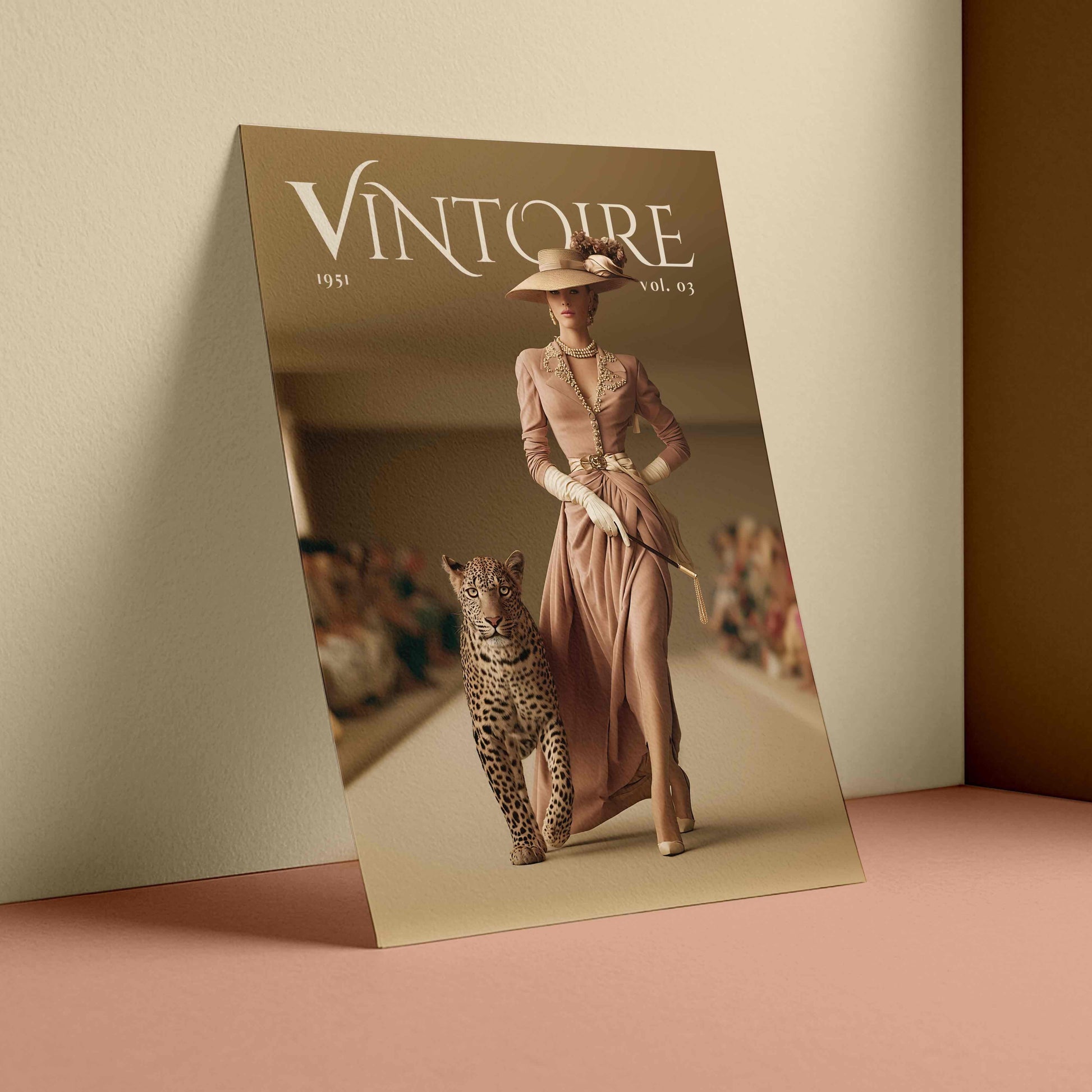 A fashion magazine or poster titled "VINTOIRE" leaning against a beige wall on a dusty pink surface. The cover shows a woman in a long blush pink dress and hat walking with a leopard in a runway setting.
