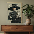 A framed fashion poster featuring a woman in a black hat and coat with the word VINTOIRE. The poster is displayed in different rooms with furniture, plants, and wall decor.