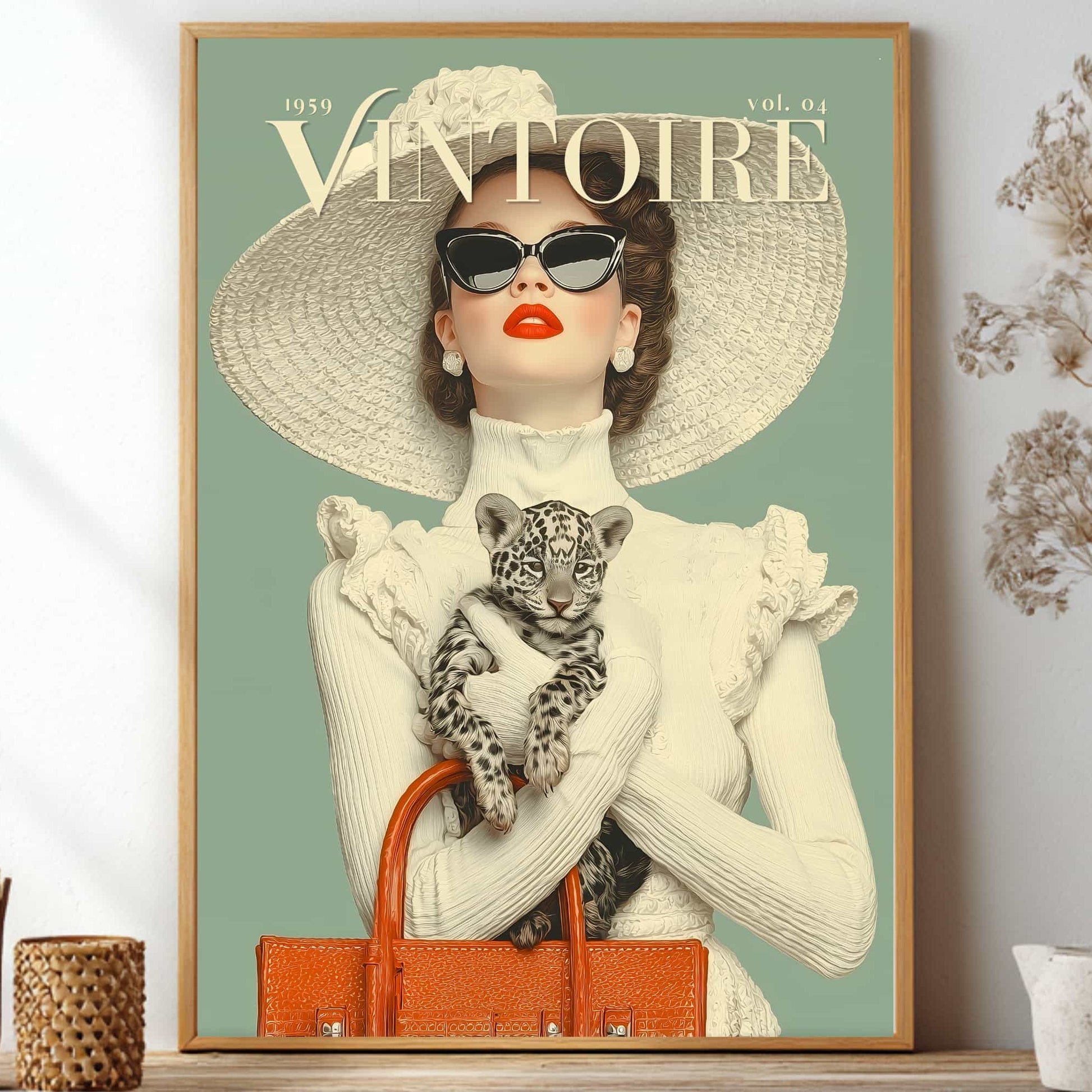 A framed vintage-style fashion poster on a shelf, showing a woman in a large white hat and sunglasses holding a leopard cub, with the title 'VINTOIRE' at the top. The room setting includes dried flowers and small decor items on both sides.