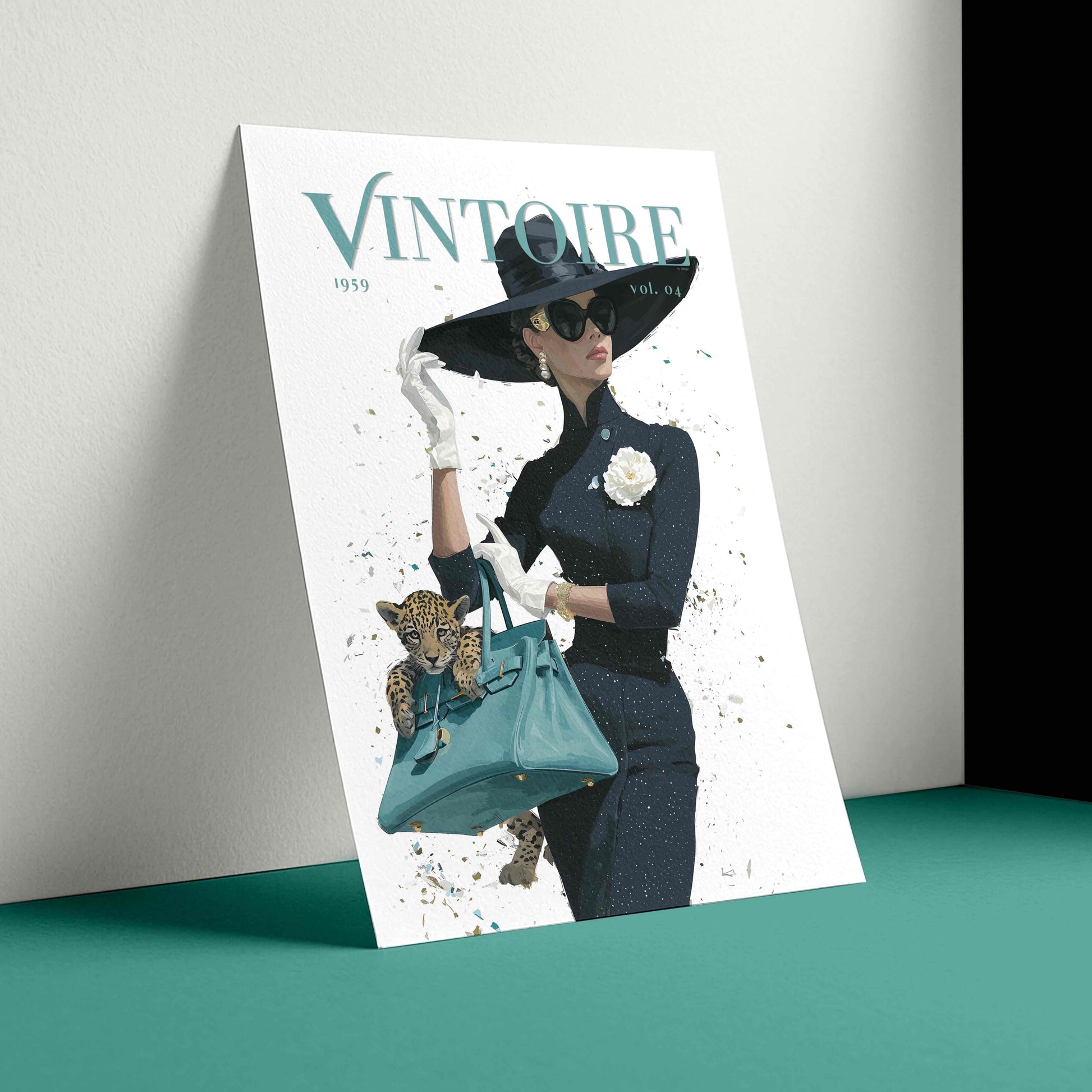 A fashion magazine cover titled 'VINTOIRE' leaning against a light gray wall on a teal surface. The cover features a woman in a black hat, sunglasses, and dark outfit holding a teal handbag with a leopard cub inside, set against a white background with black and teal tones.
