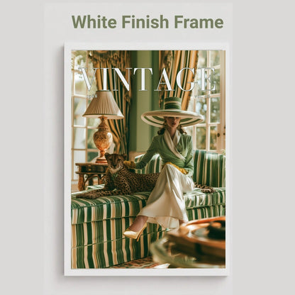 A framed art print featuring a vintage-style photograph of a woman in a green striped dress and wide-brimmed hat sitting on a matching sofa, with a leopard at her side. The print is housed in a white frame, set against a light gray background with the text 'White Finish Frame' above it.