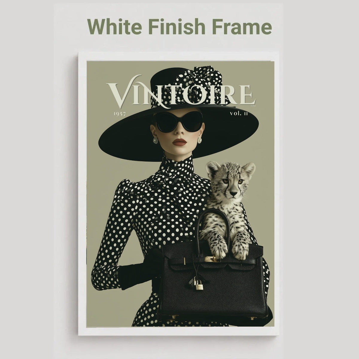 A framed art print featuring a vintage-style fashion magazine cover with the title 'VINTOIRE'. The cover shows a woman in a black and white polka dot outfit with a wide-brimmed black hat, sunglasses, and a black handbag holding a spotted kitten.