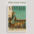 A vintage-style framed poster or print featuring a woman in a green patterned dress standing beside a leopard, with the large word VINTAGE at the top. The frame is white, and the image is shown against a light gray background with the text 'White Finish Frame' above it.