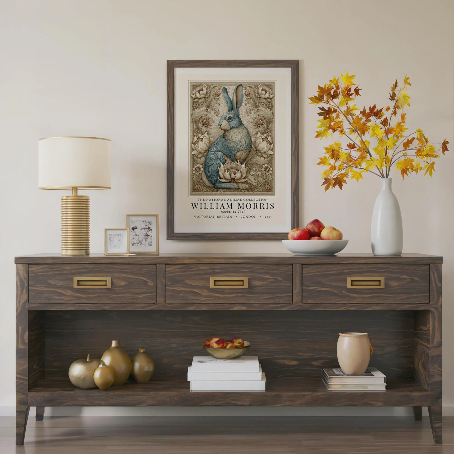 Wooden console table with decorative items including a lamp, framed artwork, and vases. William Morris inspired exhibition poster.