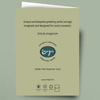 A greeting card shown flat against a muted sage green background. The card is a pale warm beige/olive tone with black text and a central logo reading 'inagi' and 'Greeting Cards.