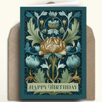 A square floral birthday card with an Art Nouveau style illustration in teal, cream, and gold, shown with a brown kraft envelope behind it on a light beige background.