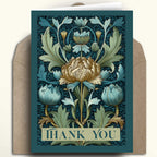 A square floral thank you card with an Art Nouveau design, featuring a large central cream flower and blue-green foliage on a dark teal background, shown with a brown kraft envelope behind it.