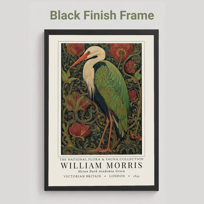 Black framed artwork of a William Morris inspired heron exhibition poster in a jewel-toned palette of forest green, antique crimson and old gold, featuring a grey heron amid ornate pimpernel blooms and curling vines — Victorian Arts and Crafts style, framed print.