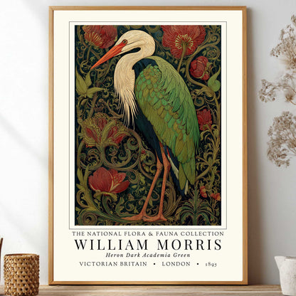 William Morris inspired heron exhibition poster in a jewel-toned palette of forest green, antique crimson and old gold, featuring a grey heron amid ornate pimpernel blooms and curling vines — Victorian Arts and Crafts style, framed print.