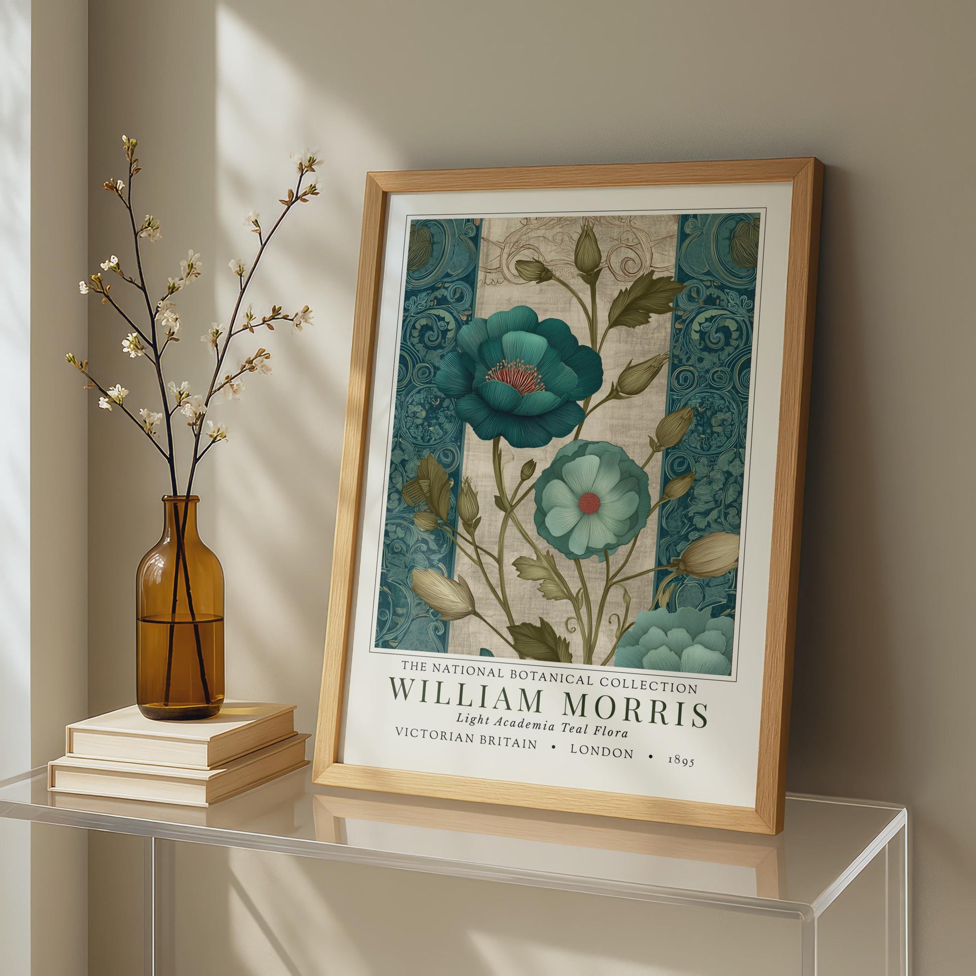 Framed artwork of floral design on a shelf with books and a vase. A framed botanical print showcasing teal flowers with red centers and green foliage. The print is from the William Morris collection, with text indicating "Victorian Britain" and "London 1895". The artwork has a vintage style.