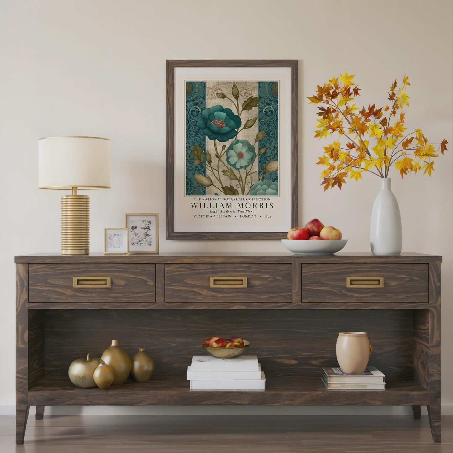 Wooden console table with decorative items including a lamp, framed artwork, and vases. A framed botanical print showcasing teal flowers with red centers and green foliage. The print is from the William Morris collection, with text indicating "Victorian Britain" and "London 1895". The artwork has a vintage style.