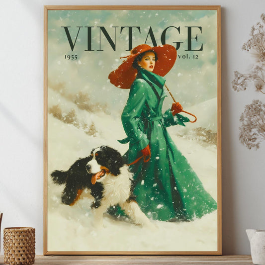 A framed vintage-style art print featuring a woman in a green coat and red hat walking a dog in the snow, with the word 'VINTAGE' at the top. The framed print is displayed on a shelf against a light wall, surrounded by decorative dried flowers and small vessels.