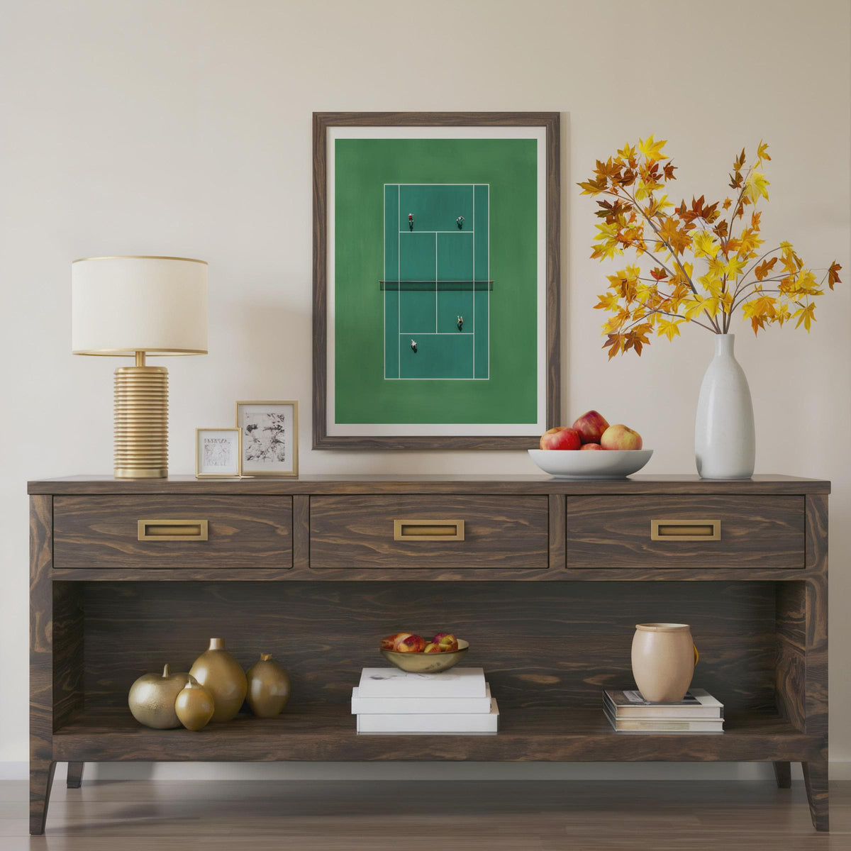 Wooden console table with decorative items including a lamp, framed picture, and vase.Framed artwork of a tennis court in miniature from above 