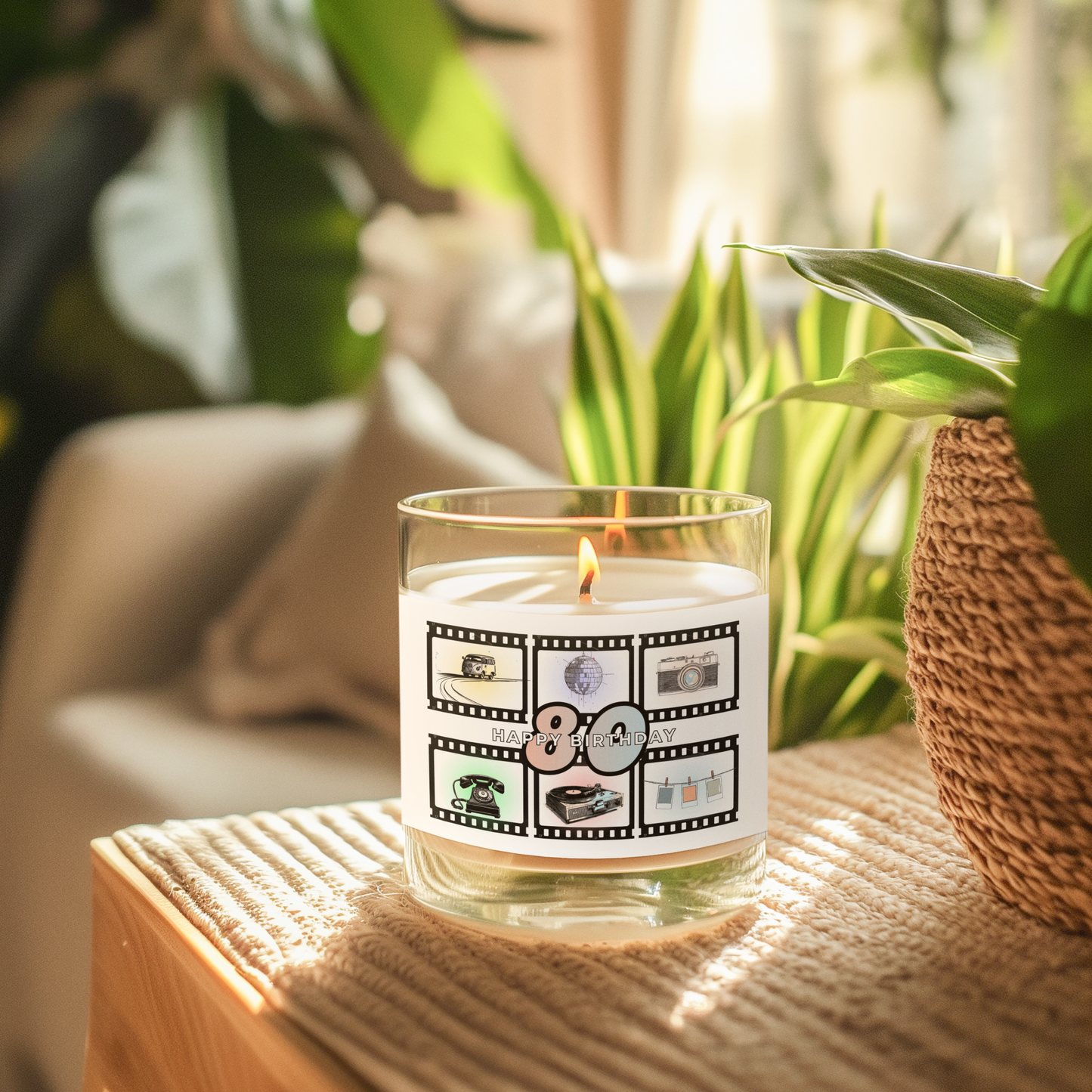 Candle with a 'Happy Birthday' '80' -themed label on a white surface with a plant in the background