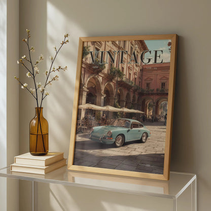 Framed artwork of a vintage car on a table with a vase and books.Vintage 1950s Porsche 911 classic car poster in a black frame on a white living room wall